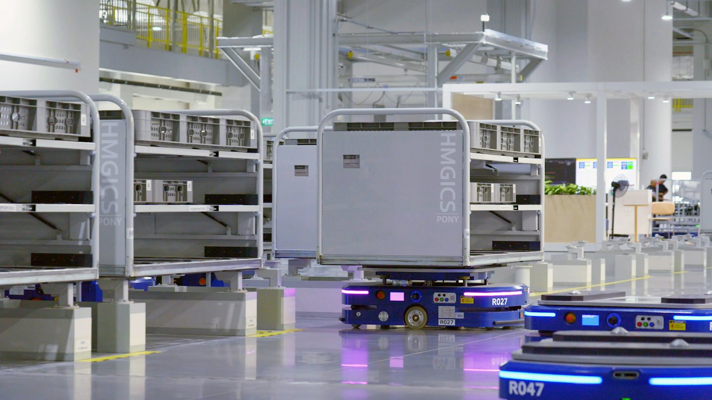 Autonome Gabelhubwagen transportieren Wagen in einem modernen Lager.